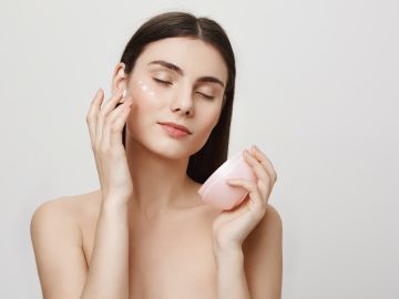 Mujer aplicando crema antiarrugas en el rostro