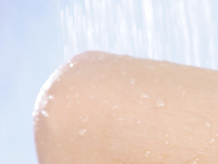 Mujer lavando su cabello con shampoo sin sal ni sulfato