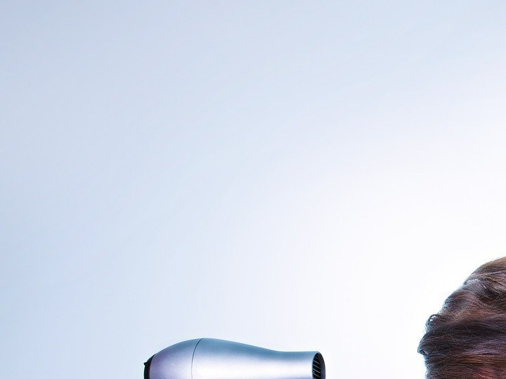 Mujer usa secadora para el cabello
