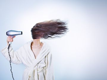Mujer usa secadora para el cabello