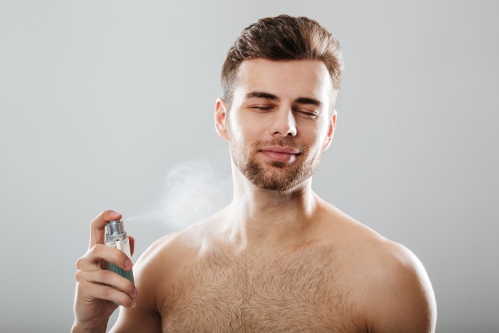 hombre perfumándose