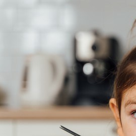 niña comiendo en un tazón negro