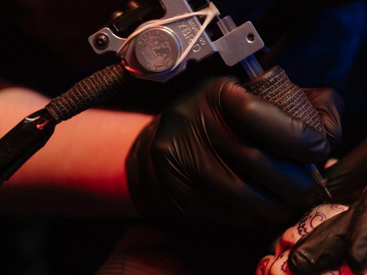 persona tatuándose la mano