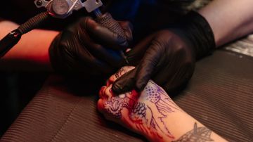 persona tatuándose la mano