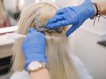 mujer tiñendo las raíces de su cabello