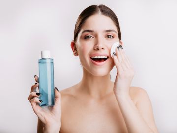 Mujer limpiando su rostro con tónico