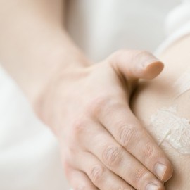 mujer untándose crema en la barriga