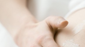 mujer untándose crema en la barriga