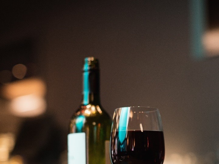 botella y copa de vino tinto sobre la mesa