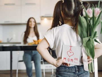 niña de espaldas con letrero de I Love Mom