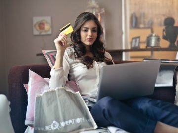 mujer con laptop y tarjeta de crédito