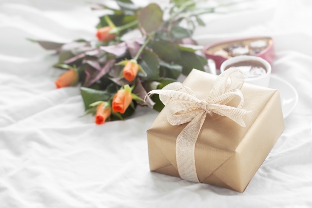 flores y regalo sobre la cama