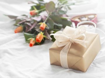 flores y regalo sobre la cama