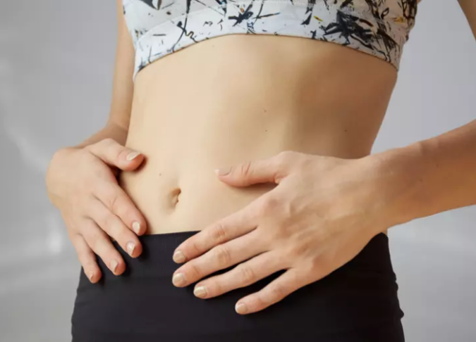 mujer tocándose el abdomen