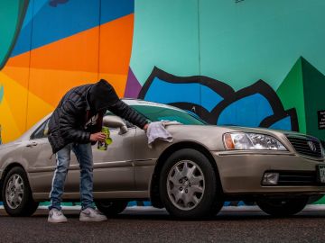 hombre limpiando un auto