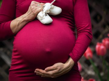 mujer embarazada con zapaticos de bebé