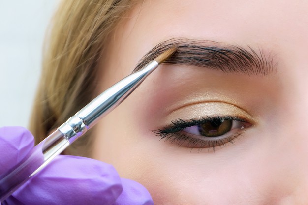 mujer tiñendo sus cejas