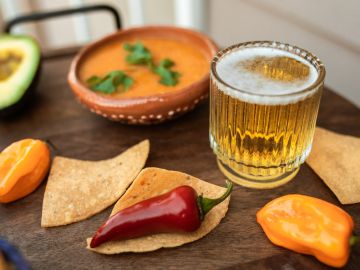 Mesa con ají picante, nachos y cerveza