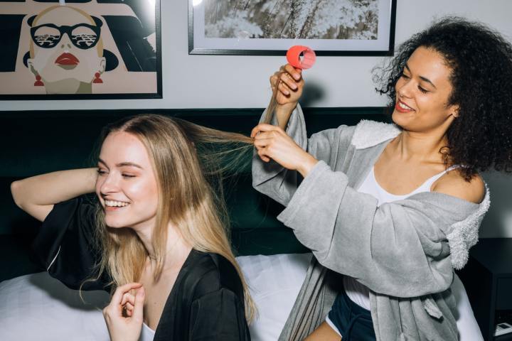 Mujer peinando a su amiga