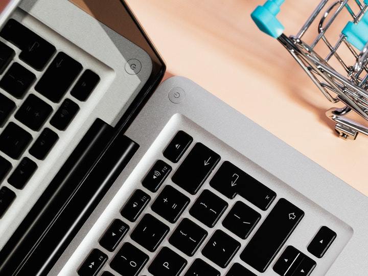 Laptop con carrito de compra y dinero