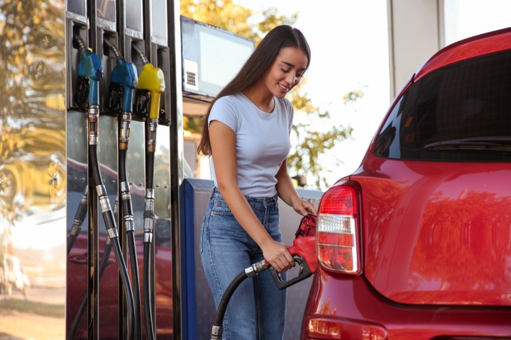 mujer llenando tanque de gasolina